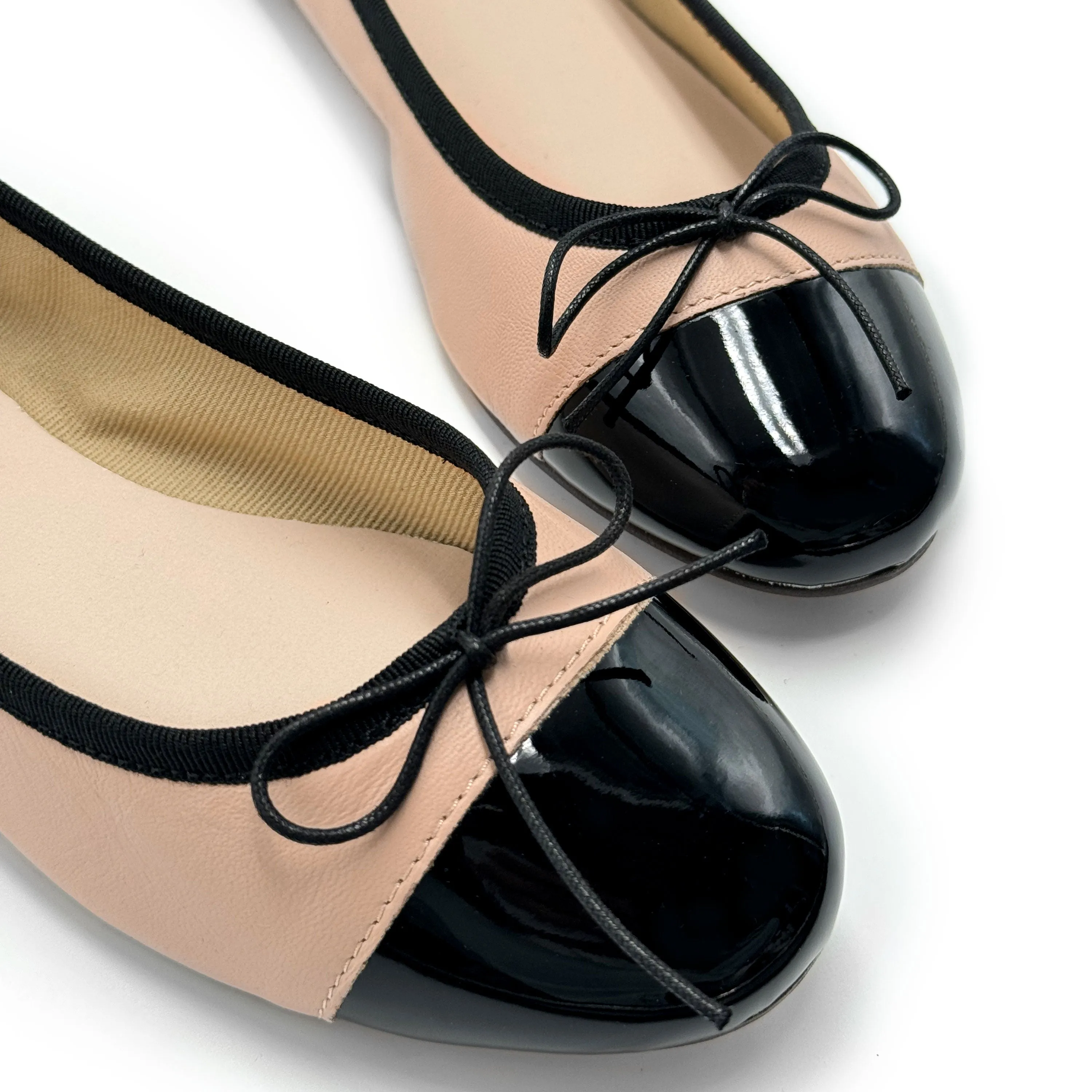 Blush pink leather ballet flats with black patent toe